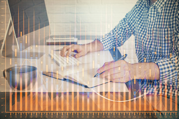 Double exposure of stock market chart with man working on computer on background. Concept of...