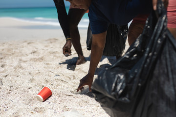 Old couple collecting waste at the beach