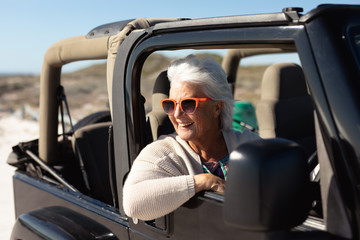 Old woman in a car at the beach