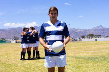 Rugbymen standing with ball