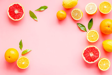 Fresh citrus frame. Oranges, tangerines, grapefruits, leaves on pink background top-down copy space - obrazy, fototapety, plakaty