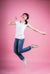 Jump women, Full-length body photo delighted funny  Braces Asian lady people young  girl raise hands to yeah achievement content isolated wear a fashionable T-shirt, jeans on pink background