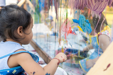 Cute Little Girl Is Painting On Glass outdoor. © tienuskin