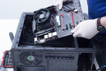 Hands of a technician assembling computer hardware parts new cpu is being mounted unto the motherboard
