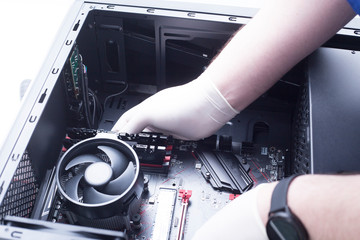 Hands of a technician assembling computer hardware parts new cpu is being mounted unto the...