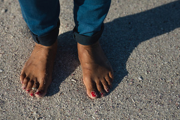 Senior woman standing on the beach bare feet