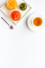 Fruit jam near tea on white kitchen desk frame copy space