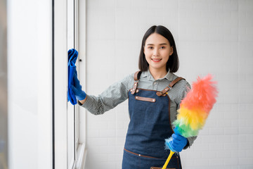 Maid Cleaning Service Concept,Beautiful asian maid women smiling and holding microfiber and cleaner spray for cleaning service feeling happiness  confident ,copy space in room - obrazy, fototapety, plakaty