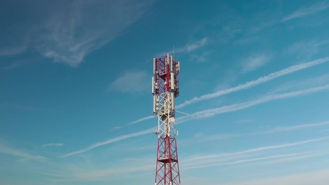 Telecommunication tower against beautiful sky with animating skull popping up, representing hazard from high frequency radiowaves.