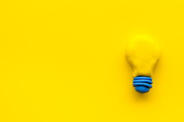 Invention concept. Bulb icon on yellow background top-down copy space