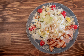 Caesar salad with roasted chicken and tomatoes.