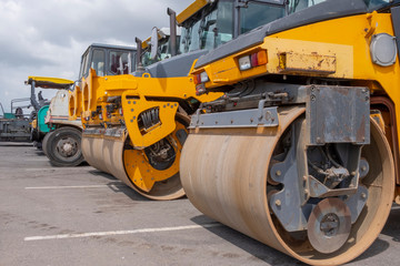 Yellow road rollers and an asphalt paver.