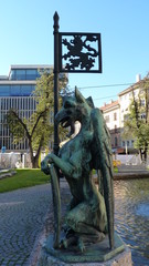 Naklejka premium Old marble statue depicting evil form located in the city center, bright sunny day
