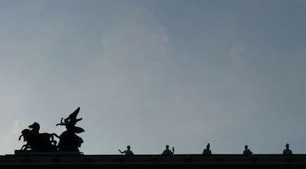 Old marble statue depicting evil form located in the city center, bright sunny day