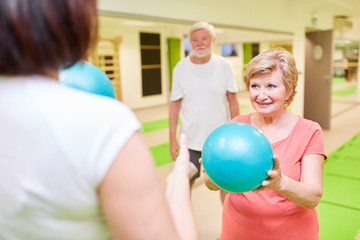 Trainer und Senior Frau mit einem kleinen Gymnastikball