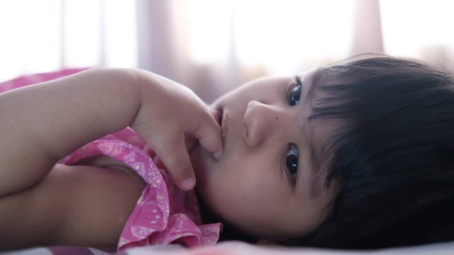 Close up of abby child laying on bed 