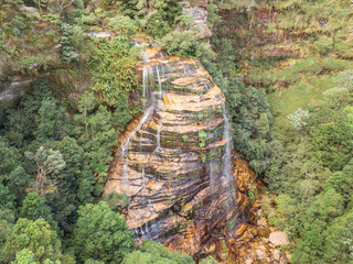 Waterfalls in Blue Mountains Australia. DRONE. Dramatic views of peaks, rock, valley, landscape, green rainforest jungle. Adventure, freedom, fun concepts. Tourist mountain trek. Shot in Sydney, NSW.