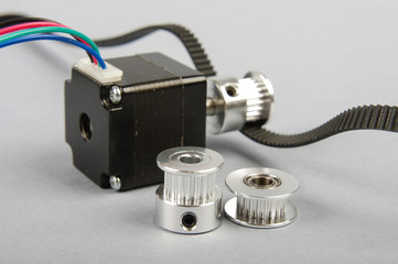 Stepper motor and timing pulley on the gray background