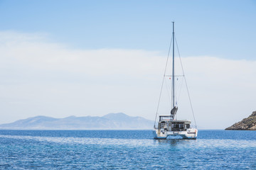 Beautiful bay with sailing boat yacht catamaran. Sail boat in a mediterranean sea. Yachting, travel, active lifestyle, summer fun and enjoying life concept