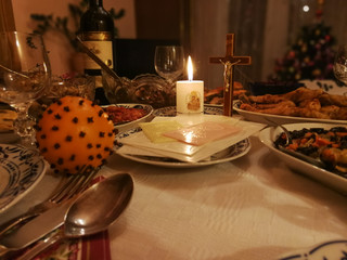 Lithuanian Christmas Eve table with Christmas wafers, candle and various dishes