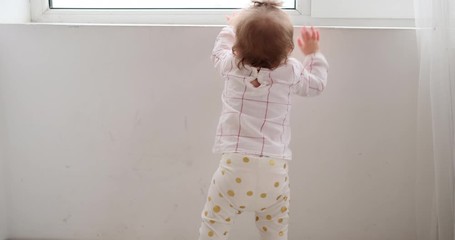 Baby girl crawling and trying to look out through window