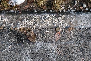 De-icing chemicals on the asphalt pavement. Pavement is sprinkled with technical salt or salt mixtures based on it.