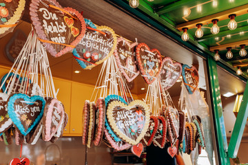 Naklejka premium Gingerbread Hearts at the German Christmas Market. Traditional gingerbread with different inscriptions in German at a fair in Germany