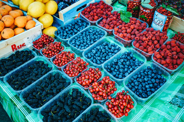 A mix of fresh berries on the market, strawberries, blueberries, raspberries, blackberries, cherries and red currants