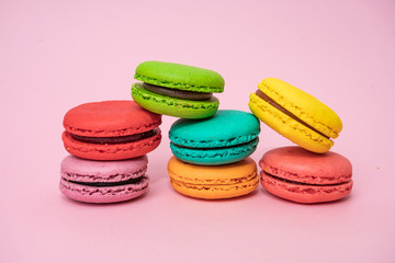 Fototapeta na wymiar Multicolored macaroons on pink background. Sweet and colourful french macaroons