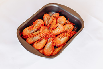 Bowl of fresh shrimp on white background
