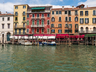 Fototapeta na wymiar Boats in a canal in venice surrounded by restaurants