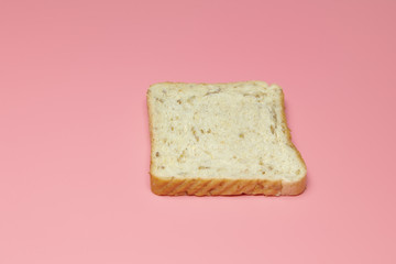Slice of bread on a pink background. Close-up. Concept: breakfast, farm, restaurant, cafe