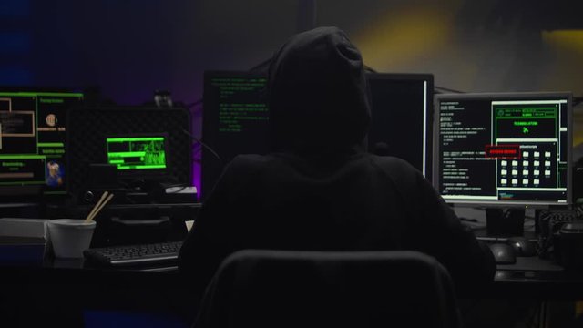 Teenage Hacker Girl in dark hood Attacks Servers in dark room