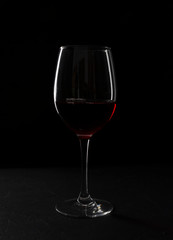 Closeup of glass of wine against dark baclground. Alcohol beverage