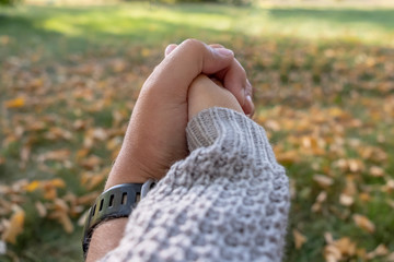 Man holding woman's hand in park...Young couple in love in the autumn park holding hands. Family concept.