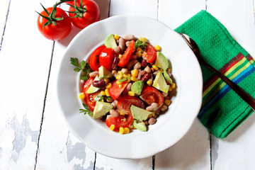 Mexican-style vegetable salad with beans, avocado, tomatoes, corn, and chickpeas