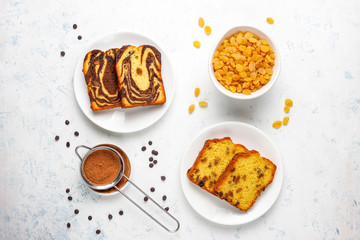 Traditional raisin marble cake slices with raisins and cocoa powder on light background,top view
