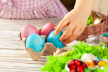 Little girl's hand holding painted Easter egg. Close up shot