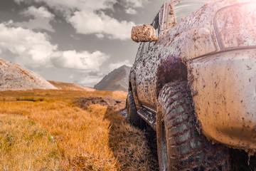 Adventure travel concept background. 4x4 off-road suv car stuck in mud. Adventure travel concept...