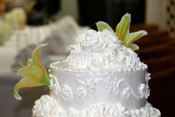 Top of a three- layer wedding cake with real flowers, soft background