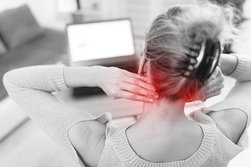Woman working on a laptop and having headache and neck pain.