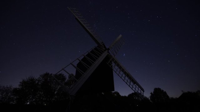 The night sky rotating over a windmill in Cambridgeshire. Spinning sky over a stationary windmill.