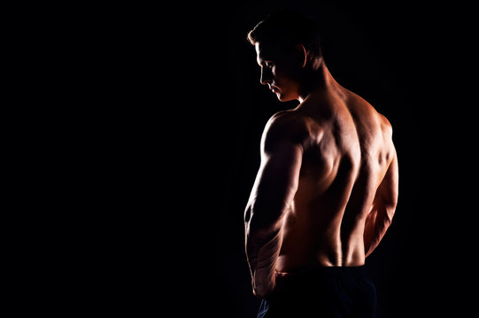 Strong, fit and sporty bodybuilder man over black background.