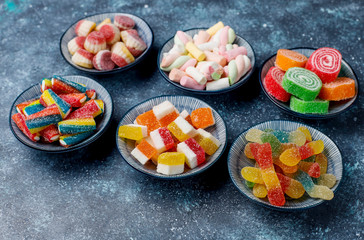 Colorful candies, jelly and marmalade on dark grey background,top view