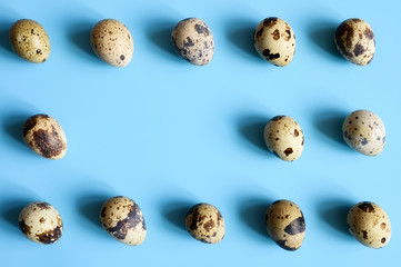 quail eggs on a blue background. a regular pattern. space for text