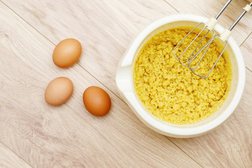 Cake batter in bowl with stir bar and eggs on wood