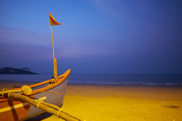Old fishing boat on the sandy shore. In Goa