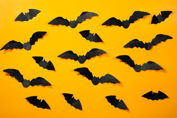 Halloween paper decorations concept. Black paper bats on a orange background. Halloween concept.