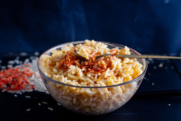 rice with saffron on a dark background in a glass dish