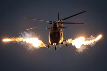 Aluminium Prints Helicopter Military helicopter in flight firing off flare decoys at night.